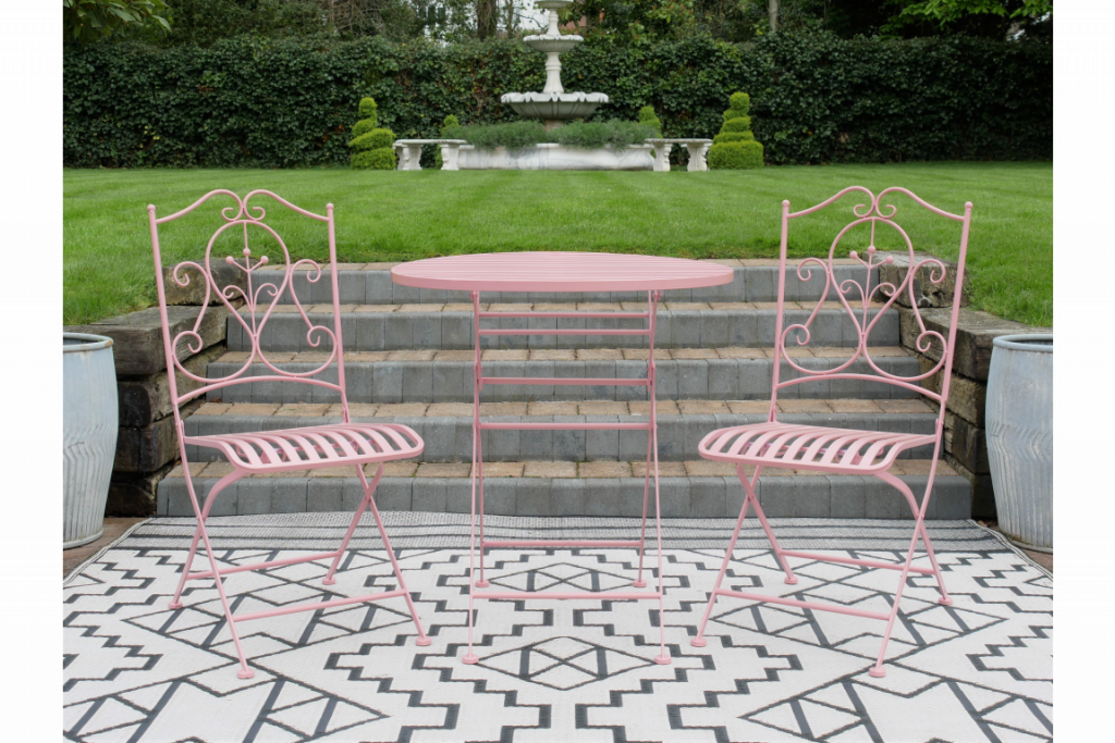 Salon de jardin en métal couleur rose dans un style ancien. Les trois pièces sont pliables pour un rangement facile et les chaises sont courbées pour une assise confortable. Un bel ensemble en métal pour décorer votre jardin ou votre terrasse.