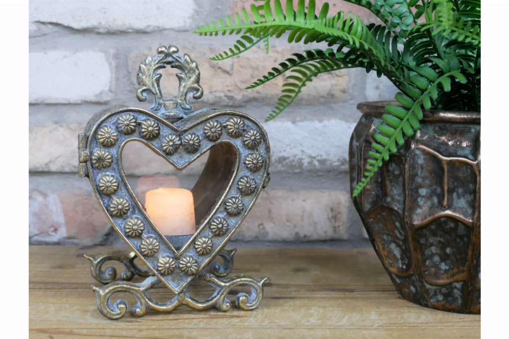 Petite lanterne vitrée en forme de cœur. Cette jolie décoration en métal s'ouvre par une porte sur le devant pour pouvoir changer la bougie et nettoyer les deux vitres.