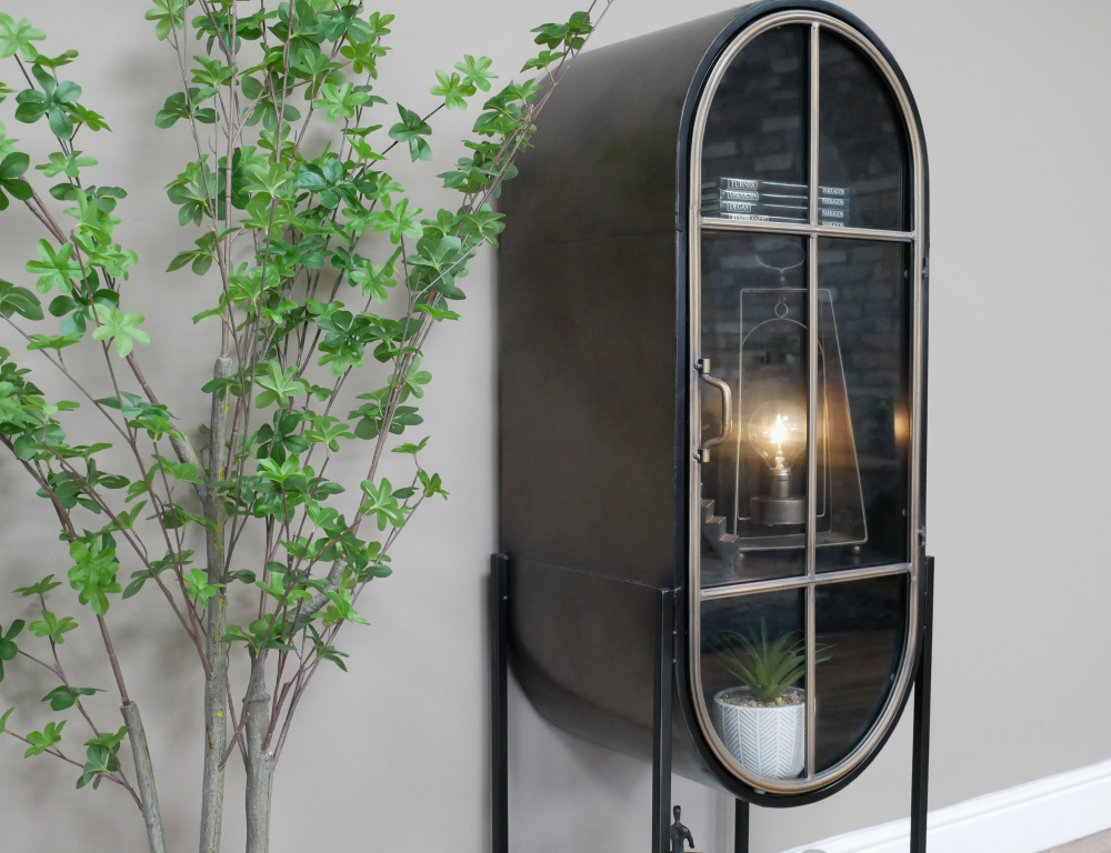 Vitrine en métal forme cintrée ellipse avec une porte, deux étagères à l'intérieur et une en extérieur. Un beau meuble entièrement en métal finition anthracite et bronze dans un design moderne et sobre.