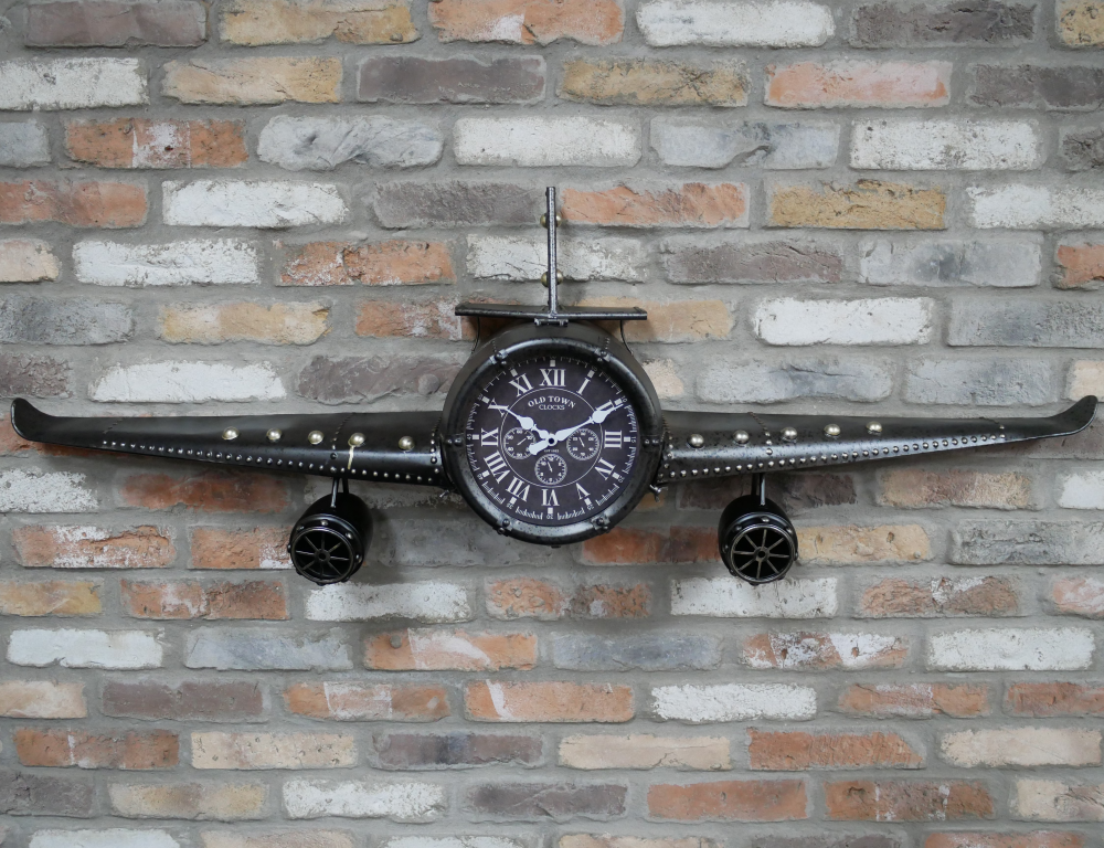 Horloge murale représentant un avion. Cet avion en métal, finition grise mouchetée, décor riveté est une horloge et une décoration murale en même temps. Le cadran qui s’ouvre vous permet de changer la pile et donne accès à un espace de rangement. Une très belle réalisation originale. Vous trouverez d'autres horloges murales dans une forme d'avion sur ce site.