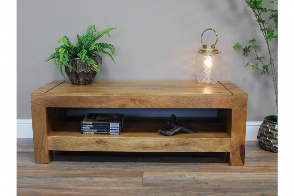 Table basse en manguier avec une étagère. Cette table en bois massif avec une finition brut et un design sobre et fonctionnel s'accorde facilement avec autre styles de mobilier.